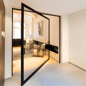 puerta corrediza moderna con marco de aluminio negro y vidrio claro, instalada con precisión en fachada residencial.
